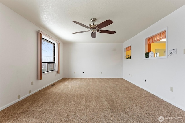 unfurnished room featuring ceiling fan, a textured ceiling, visible vents, baseboards, and carpet