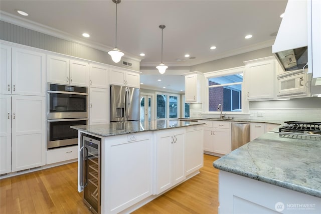 kitchen with white cabinets, wine cooler, a center island, hanging light fixtures, and stainless steel appliances