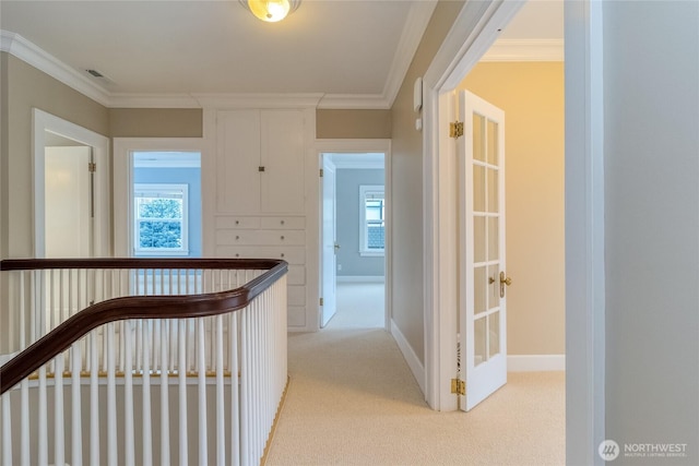 hallway with light carpet, crown molding, and visible vents