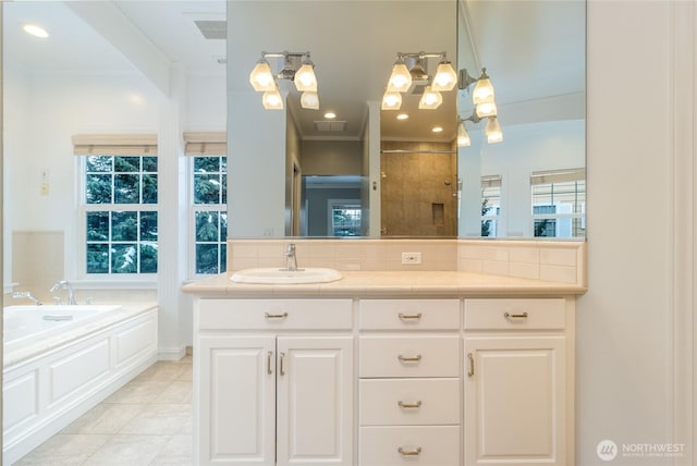 bathroom featuring a garden tub, tile patterned flooring, vanity, and a healthy amount of sunlight