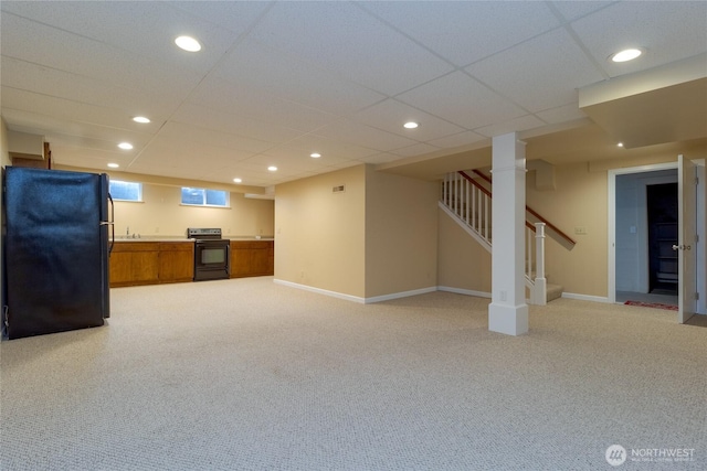 basement with light carpet, recessed lighting, stairs, and freestanding refrigerator