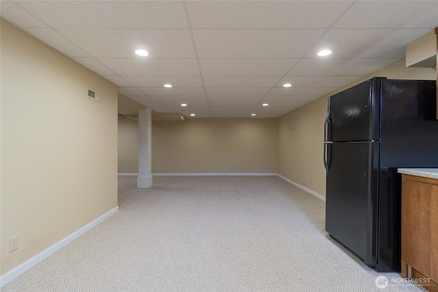 interior space featuring baseboards, visible vents, light colored carpet, and freestanding refrigerator