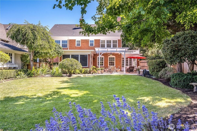 exterior space with a front yard, brick siding, fence, and a pergola