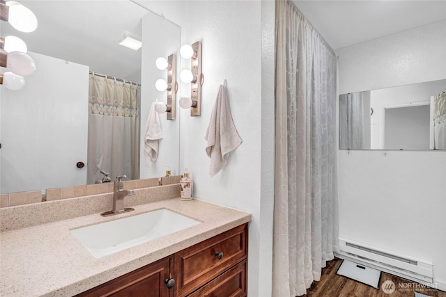 bathroom featuring wood-type flooring, vanity, and a baseboard radiator