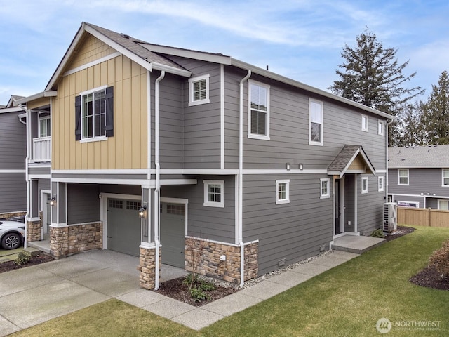 view of front of house featuring driveway, stone siding, fence, board and batten siding, and a front yard