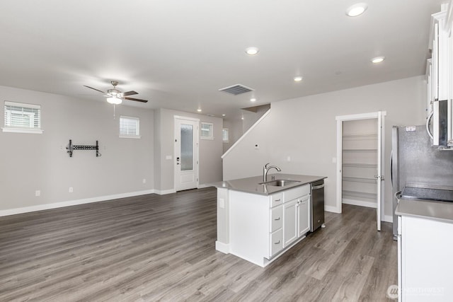 kitchen featuring stainless steel appliances, visible vents, white cabinetry, an island with sink, and wood finished floors