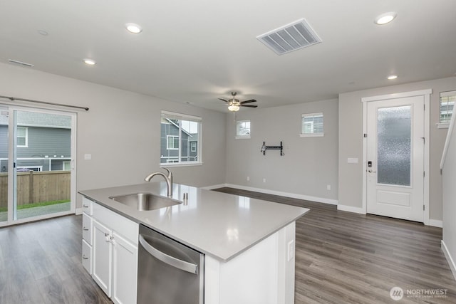 kitchen with visible vents, white cabinetry, a sink, wood finished floors, and dishwasher