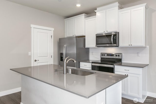 kitchen with white cabinets, appliances with stainless steel finishes, decorative backsplash, and a sink