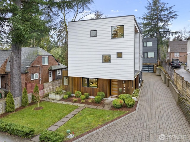 view of front of property featuring fence and a front lawn