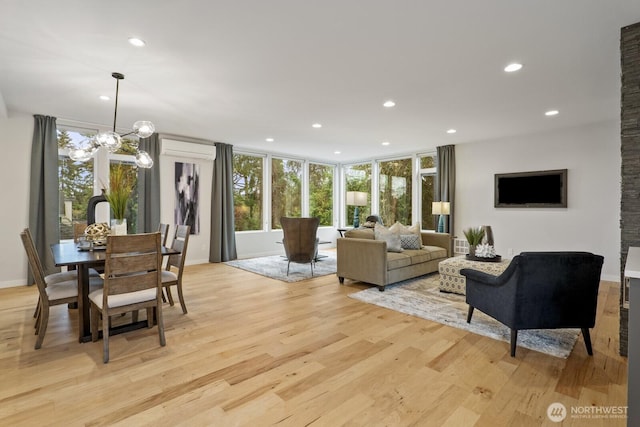 living room with a chandelier, recessed lighting, light wood-type flooring, and a wall mounted air conditioner