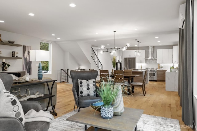 living area featuring light wood-style flooring, a notable chandelier, and recessed lighting