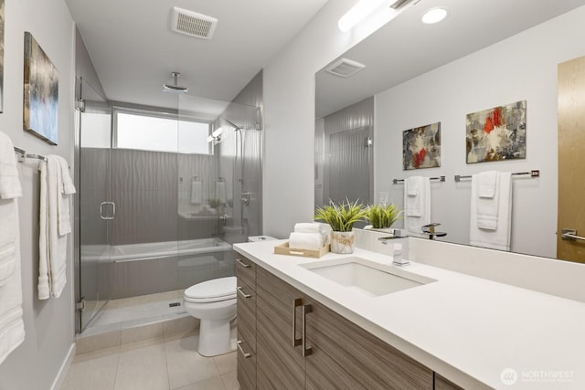 full bathroom featuring tile patterned flooring, toilet, vanity, visible vents, and a shower stall