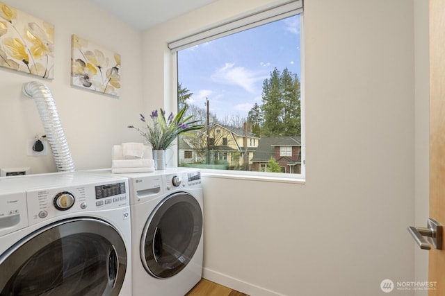 clothes washing area featuring a wealth of natural light, laundry area, and separate washer and dryer