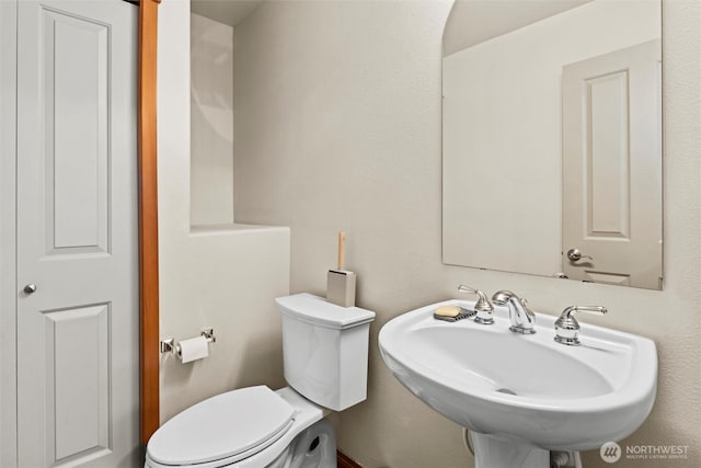 half bath with toilet and a sink