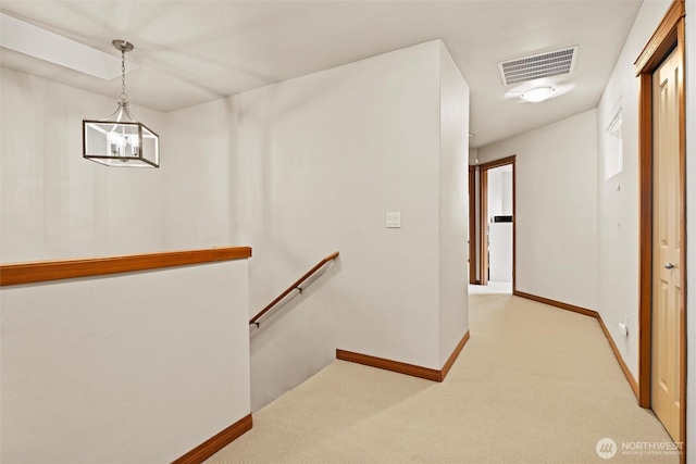 walk in closet with light colored carpet, visible vents, and a chandelier