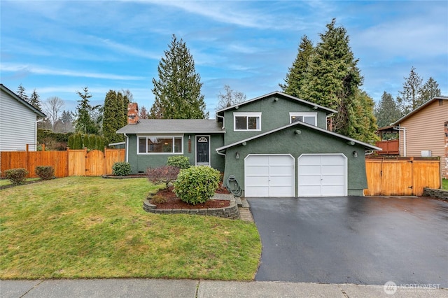 tri-level home with a garage and a front yard