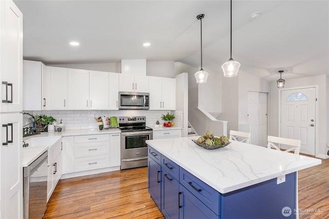 kitchen with appliances with stainless steel finishes, white cabinets, decorative light fixtures, blue cabinets, and sink