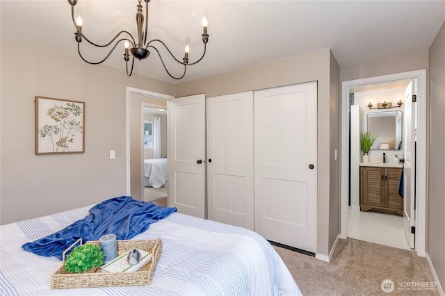 bedroom with a closet, a notable chandelier, light carpet, ensuite bathroom, and sink