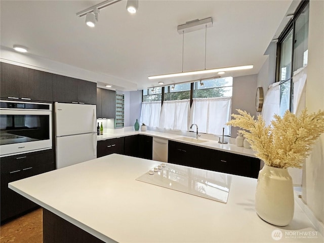 kitchen featuring light countertops, stainless steel dishwasher, wall oven, and freestanding refrigerator