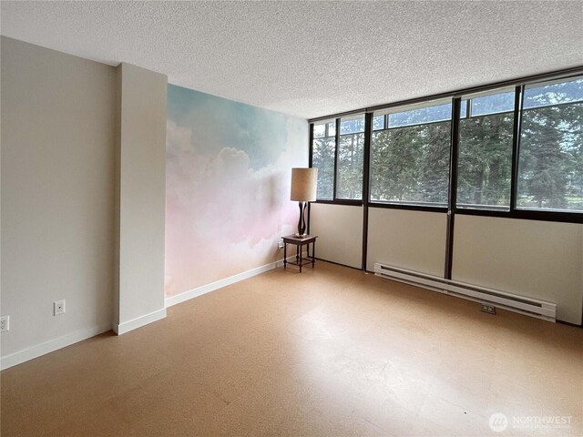 empty room featuring a baseboard radiator, baseboards, and a textured ceiling