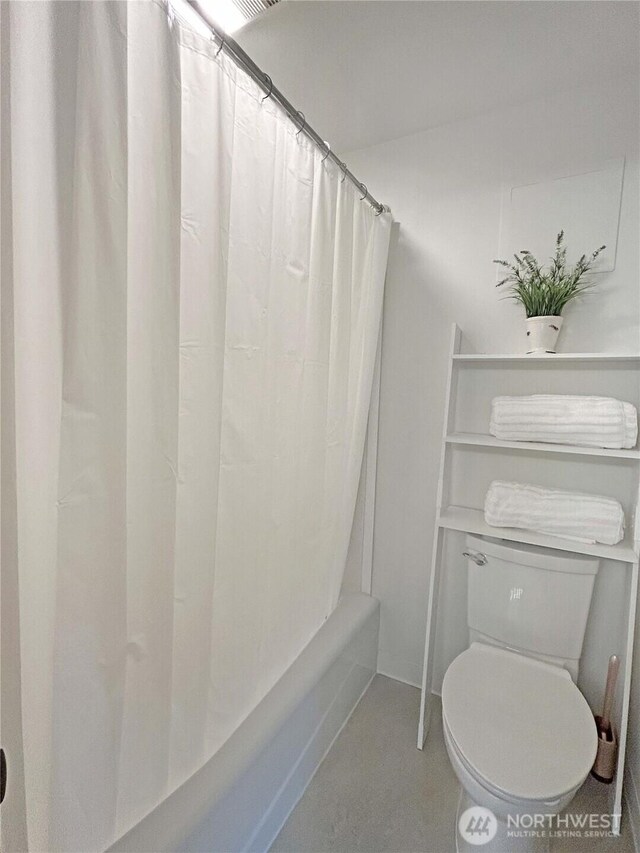 bathroom with shower / tub combo and toilet