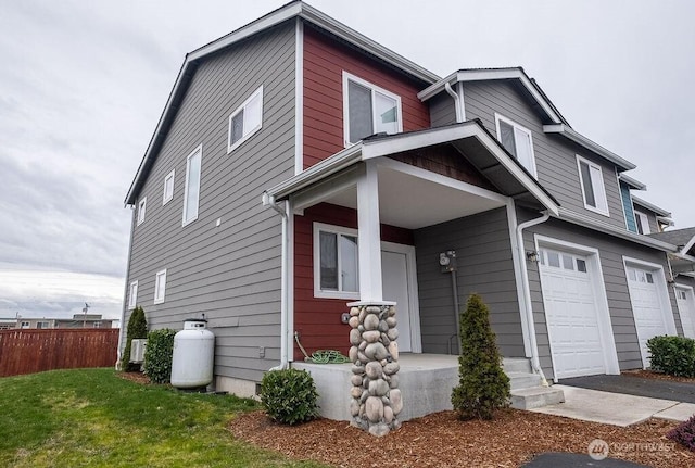 view of front of house with a garage, a front lawn, and fence