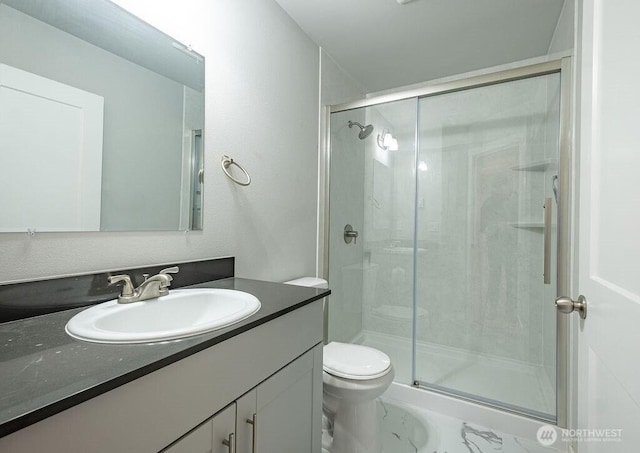 full bathroom with a stall shower, vanity, and toilet