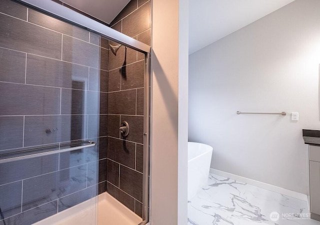 full bath with marble finish floor, a shower stall, vanity, a freestanding tub, and baseboards