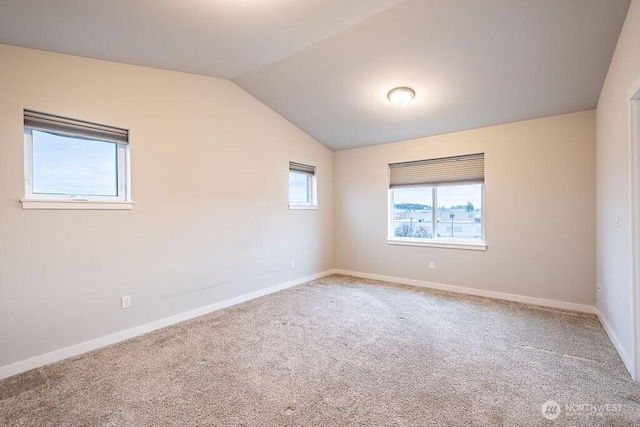 unfurnished room with carpet floors, vaulted ceiling, and baseboards