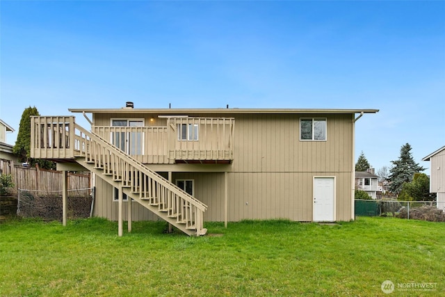 back of house with stairway, a lawn, a deck, and fence