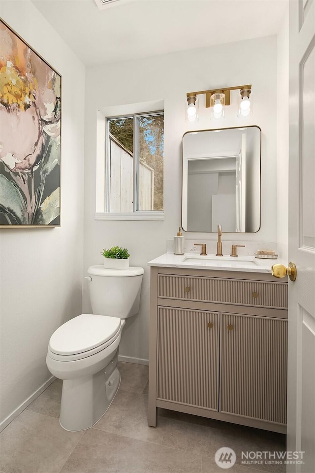 bathroom with vanity, toilet, and baseboards