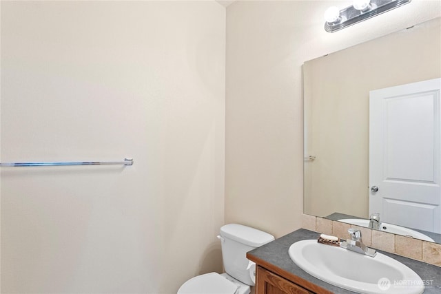 half bathroom with vanity and toilet