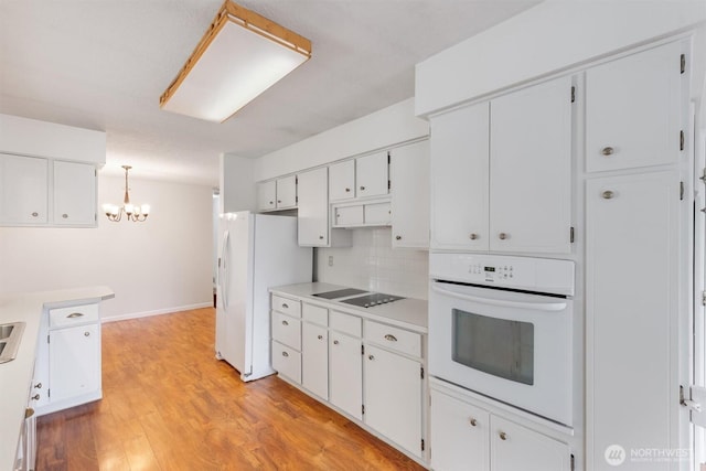 kitchen with tasteful backsplash, white cabinets, white appliances, and light wood-style flooring