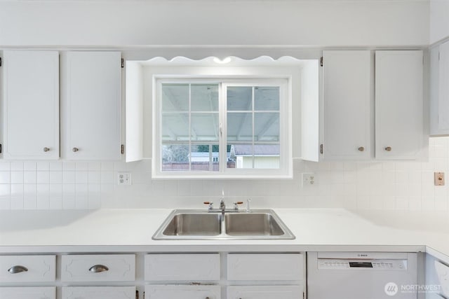 kitchen with a sink, white cabinets, light countertops, and white dishwasher