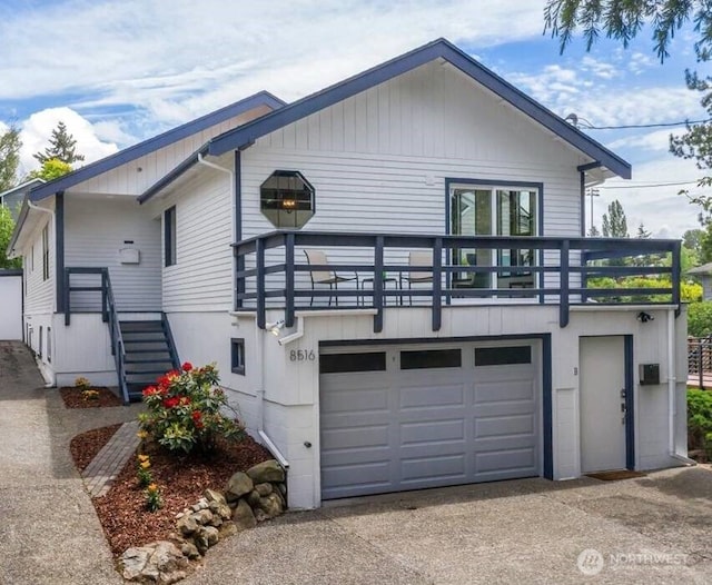 view of front facade featuring a garage, concrete driveway, and stairway