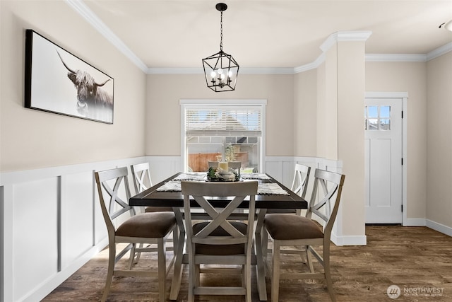 dining area with a wainscoted wall, a healthy amount of sunlight, crown molding, and wood finished floors