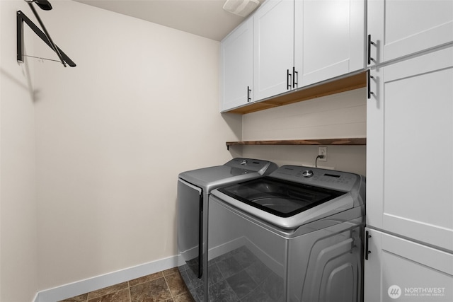 laundry area featuring visible vents, independent washer and dryer, cabinet space, and baseboards