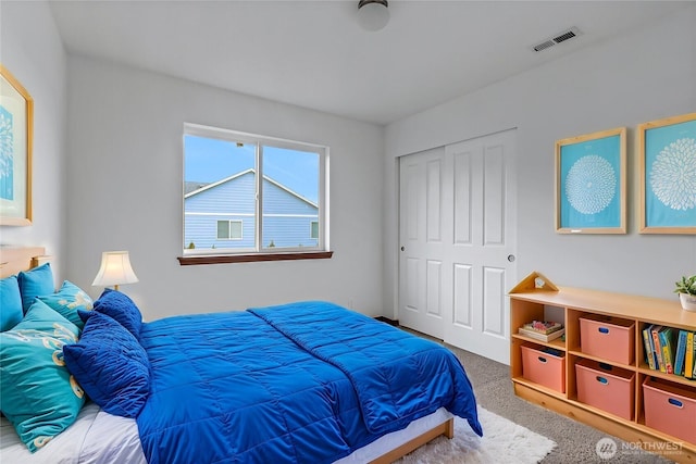 bedroom with a closet, visible vents, and carpet flooring