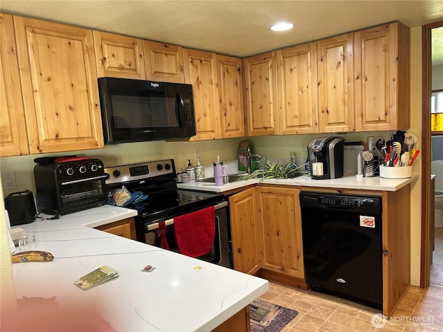 kitchen with black appliances, light countertops, and recessed lighting