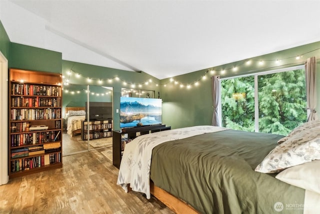 bedroom featuring lofted ceiling and wood finished floors