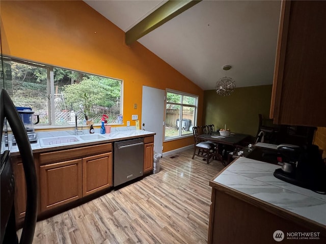 kitchen with brown cabinets, stainless steel dishwasher, light wood-style floors, a sink, and beamed ceiling