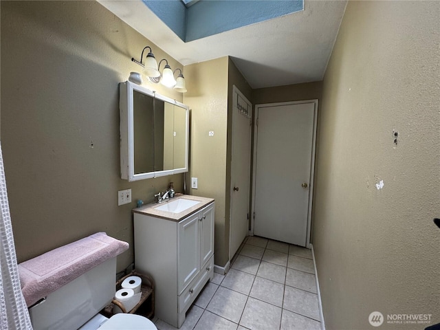 bathroom featuring toilet, tile patterned flooring, and vanity