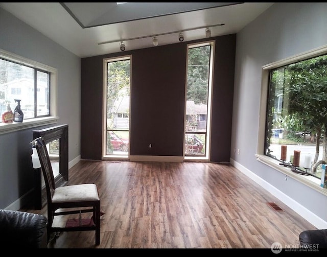 sitting room featuring wood finished floors, visible vents, and baseboards