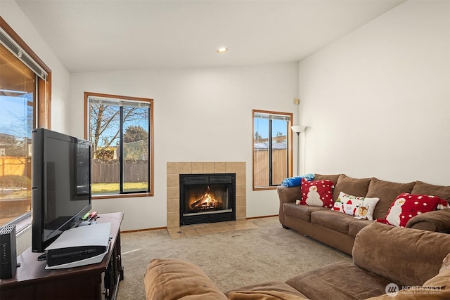 living room featuring a tile fireplace, recessed lighting, light colored carpet, baseboards, and vaulted ceiling