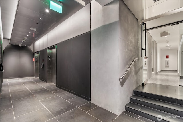 hall featuring dark tile patterned flooring and recessed lighting