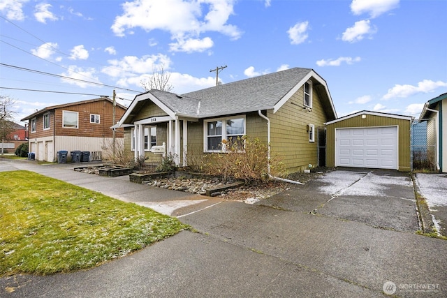 view of front of home with a front yard, a garage, and an outbuilding