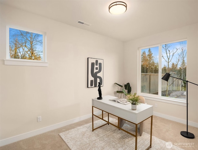 carpeted home office with a healthy amount of sunlight, visible vents, and baseboards