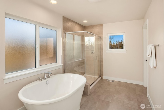 full bathroom featuring a soaking tub, a shower stall, baseboards, and recessed lighting