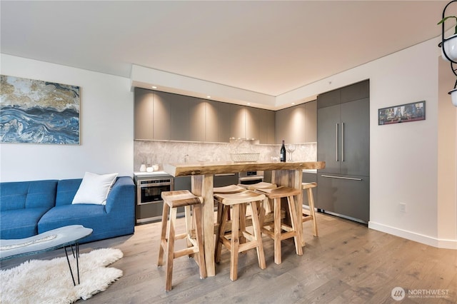 dining space featuring light wood-style flooring and baseboards