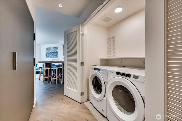 laundry area featuring recessed lighting, visible vents, separate washer and dryer, light wood-type flooring, and laundry area